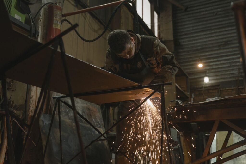 Sparks from cutting metal in a dark fabrication workshop
